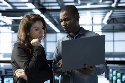 Computer scientists in data center use laptop to develop disaster recovery plans Stock Photos