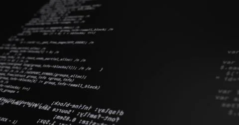 Computer screen displaying lines of code in dark room, focusing on programming Stock-Fotos