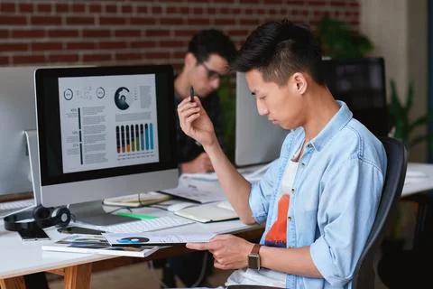 Computer screen, documents and reading with designer man at desk for review.. Stock Photos