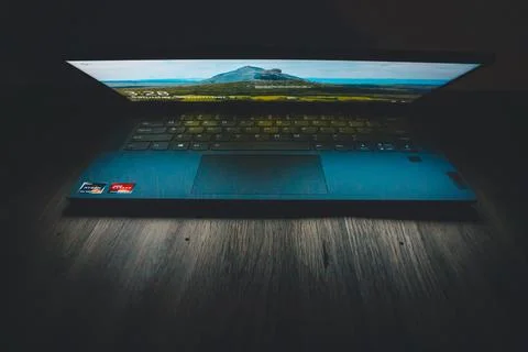 Computer screen lighting up a dark desk Stock Photos