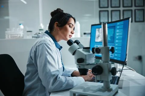 Computer screen, microscope and science with woman in laboratory for development Foto stock