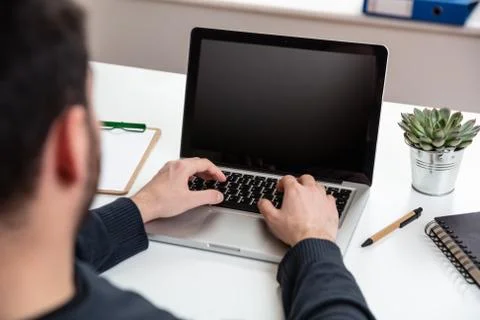 Computer screen mockup. Man working with a black blank screen laptop on a woo Stock Photos