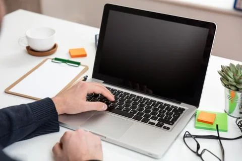 Computer screen mockup. Man working with a black blank screen laptop on a woo Foto stock