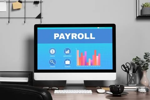 Computer screen with payroll data on table Stock Photos