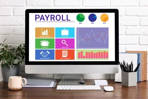 Computer screen with payroll data on table Stock Photos