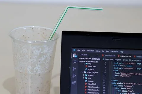 A computer screen of a programmer with code written in html 5, and an empty g Stockfoto's