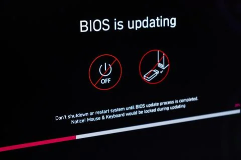A computer screen showing a BIOS update in progress with warning icons, 写真素材