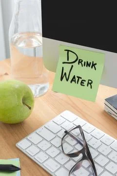 Computer Screen with Sticky Note Saying "Drink Water" as a Hydration Reminder Stock Photos