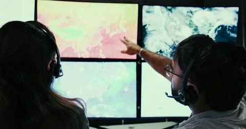 Computer screen, surveillance and back of people in control room for storm,.. Foto stock