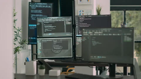 Computer screens on desk in empty data room displaying program code and Stock Footage 231448192