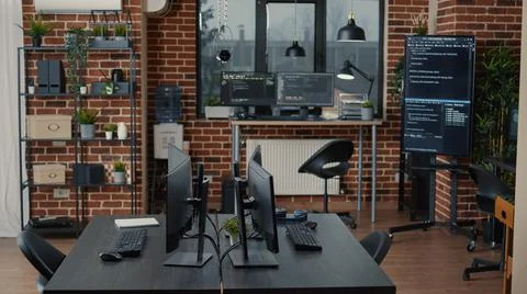 Computer screens on desk in empty software it agency office and computers in Stock Photos