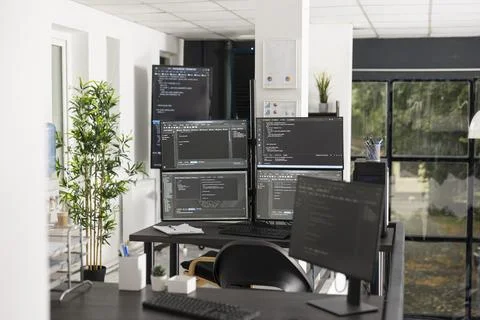 Computer screens display compiling HTML code in unoccupied office Stock Photos