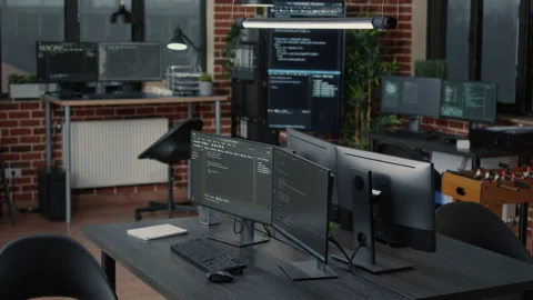 Computer screens running programming code in empty software it agency office and Stock Footage 168242113