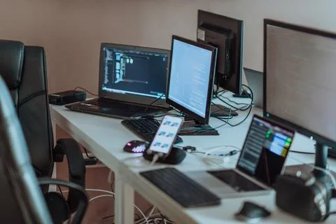 Computer screens running programming code in empty software developing agency Stock Photos