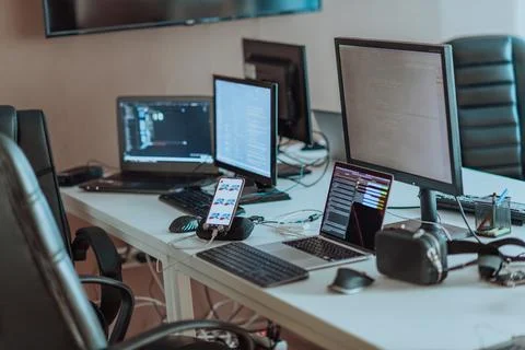 Computer screens running programming code in empty software developing agency 库存照片