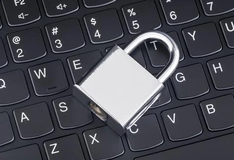 Computer security concept. Silver padlock on black laptop keyboard Stock Photos