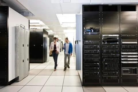 Computer server room racks with technician in background. Stock Photos
