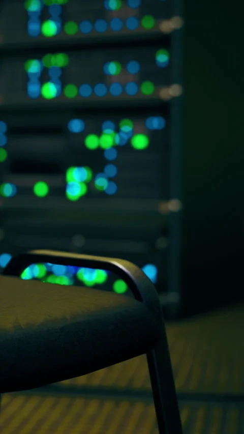 Computer server room showing a chair with colorful lights in the background Видео 336583836