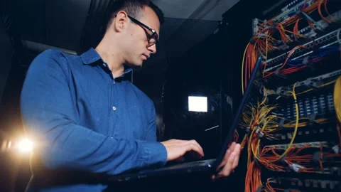 Computer servers are getting inspected by an engineer with a laptop Video stock 99089331