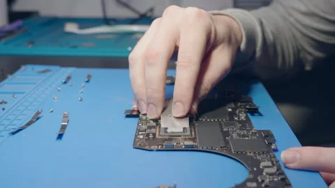 Computer service. A repairman replace the thermal grease on a laptop processor Stock Footage 262571284