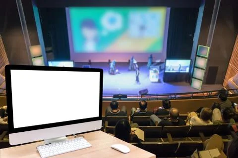 Computer set showing the white screen over the Abstract blurred photo of conf Stock Photos