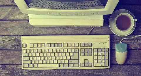 Computer setup with keyboard mouse coffee cup on wooden desk Stock Photos