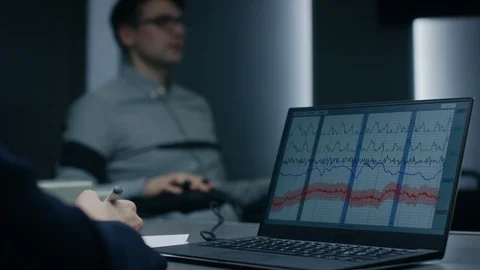 Computer Shows Physiological Measures of a Man Undergoing Lie Detector Stock Footage 94570554