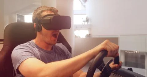 Computer simulation. Man in vr glasses racing steering wheel Stock Photos