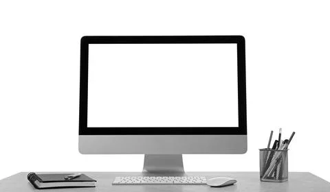 Computer with stationery on table against white background. Stylish workplace Stock Photos