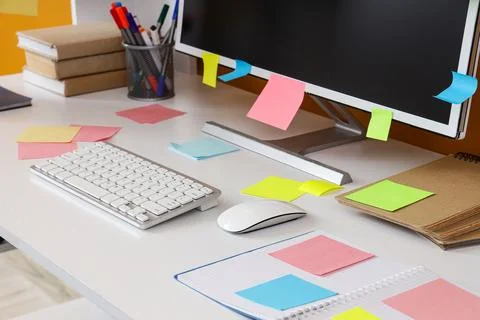 Computer with sticky notes on desk in office Stock Photos