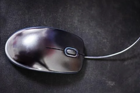 Computer stylish wired mouse on a dark background. Orgonomics of the hand a.. Stock Photos