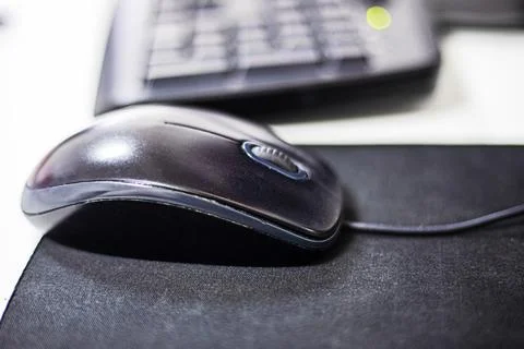 Computer stylish wired mouse on a dark background. Orgonomics of the hand a.. Stock Photos