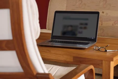 Computer on the table, cozy home interior with armchair. Reading internet new Stock Photos