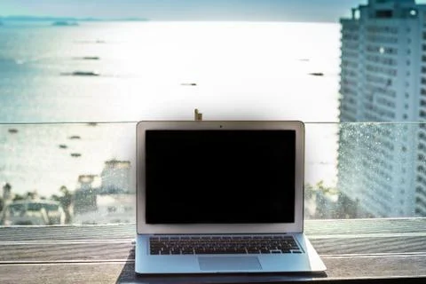 The computer is on the table near the panoramic window with a beautiful Stock Photos