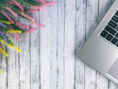 A computer is on the table, next to it is a bouquet of lavender. Stock Photos