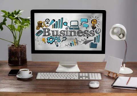 Computer on table showing blue and yellow business doodles against blurry grey Foto stock