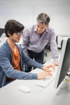 Computer teacher assisting a student Stock Photos