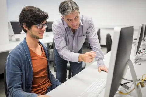 Computer teacher assisting a student Stock Photos
