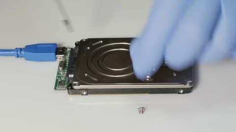 Computer technician with blue rubber gloves hard drive cover screws Video stock 74118338