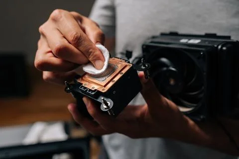 Computer technician cleaning processor cooling system with white cloth, ensuring 스톡 사진