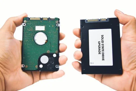 Computer technician compares a SATA harddisk and solid state drive (SSD) Stock Photos