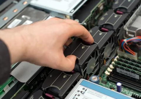 Computer technician installing cooler fan into motherboard. Stock Photos
