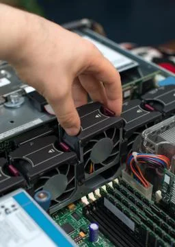 Computer technician installing cooler fan into motherboard. Stock Photos