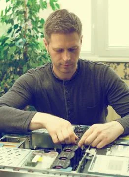 Computer technician installing cooler fan into motherboard. Stock Photos