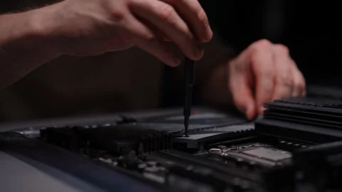 Computer technician installing ssd drive motherboard with screwdriver, upgrading Stock Footage 290927130
