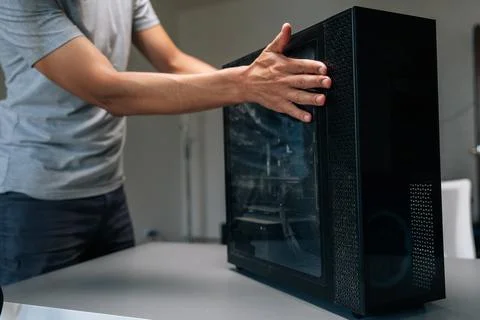 Computer technician opening side panel of desktop computer case, preparing for Stock Photos
