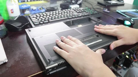Computer technician removing the bottom cover from a laptop for reparation Vidéo 102192773