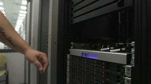 Computer technician with tats. At computer server Stock Footage 90991584