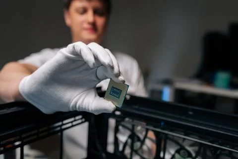 Computer technician wearing white gloves showing CPU during installation into Stock Photos