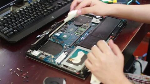 Computer technician wiping old thermal paste from CPU and heatsink in a laptop 스톡 동영상 102189159